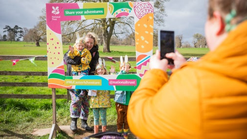 Family taking a photo in front of an Easter-themed photo frame
